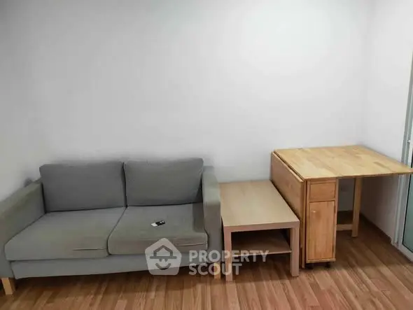 Cozy living room with modern gray sofa and wooden furniture, perfect for minimalist living.
