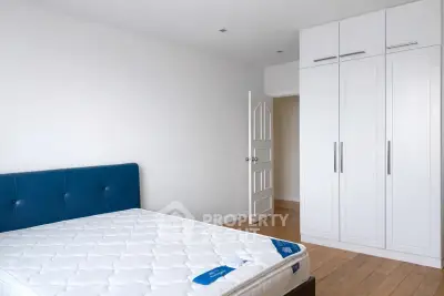 Spacious bedroom with modern wardrobe and stylish blue headboard