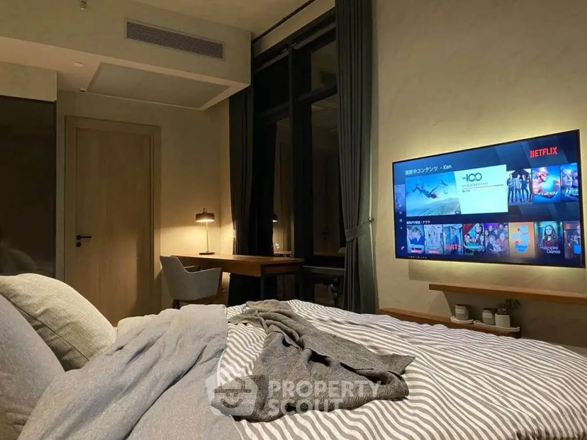 Cozy bedroom with modern decor and wall-mounted TV for entertainment.