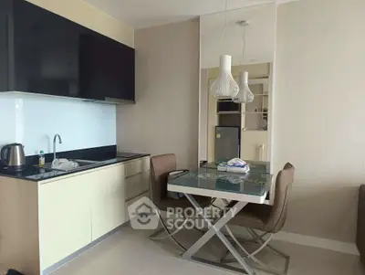 Modern kitchen with sleek cabinetry and dining area in contemporary apartment