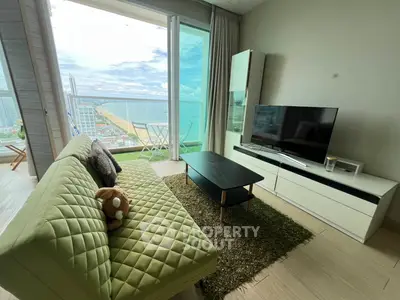 Modern living room with ocean view, stylish furniture, and large windows for natural light.