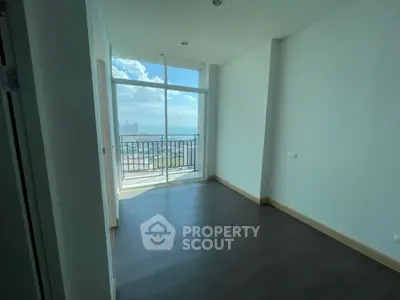 Bright empty room with large window and city view, perfect for customization.