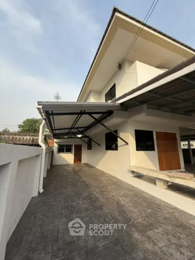 Modern two-story house with spacious driveway and covered parking area