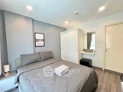 Modern bedroom with cozy gray bedding and stylish decor in a contemporary apartment.