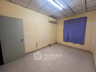Spacious room with tiled floor, air conditioning, and decorative ceiling tiles.