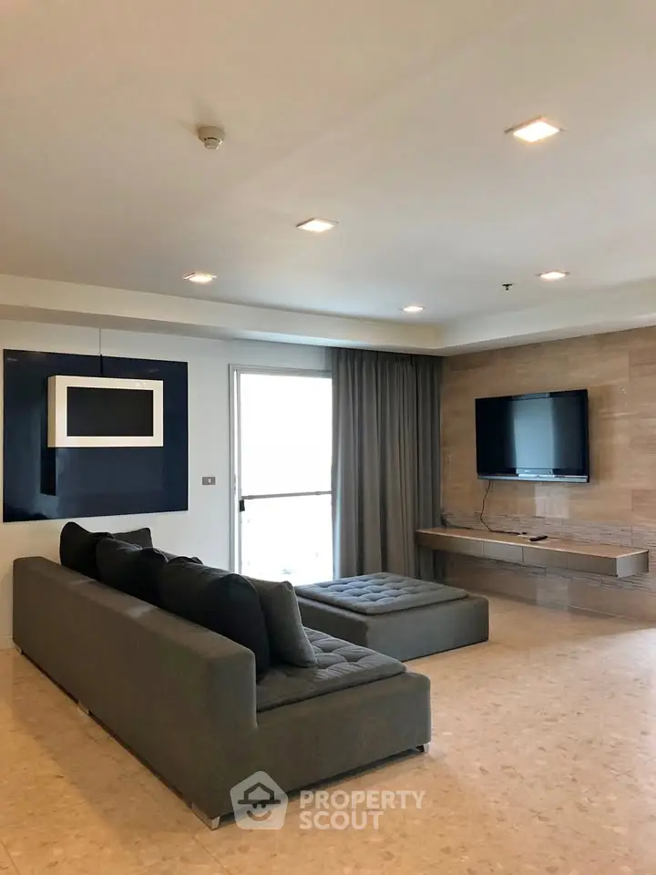 Spacious modern living room with sleek furniture and wall-mounted TV