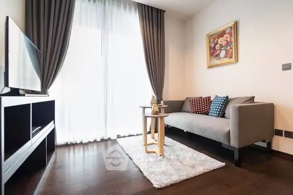 Modern living room with sleek furniture and large window, perfect for relaxation.
