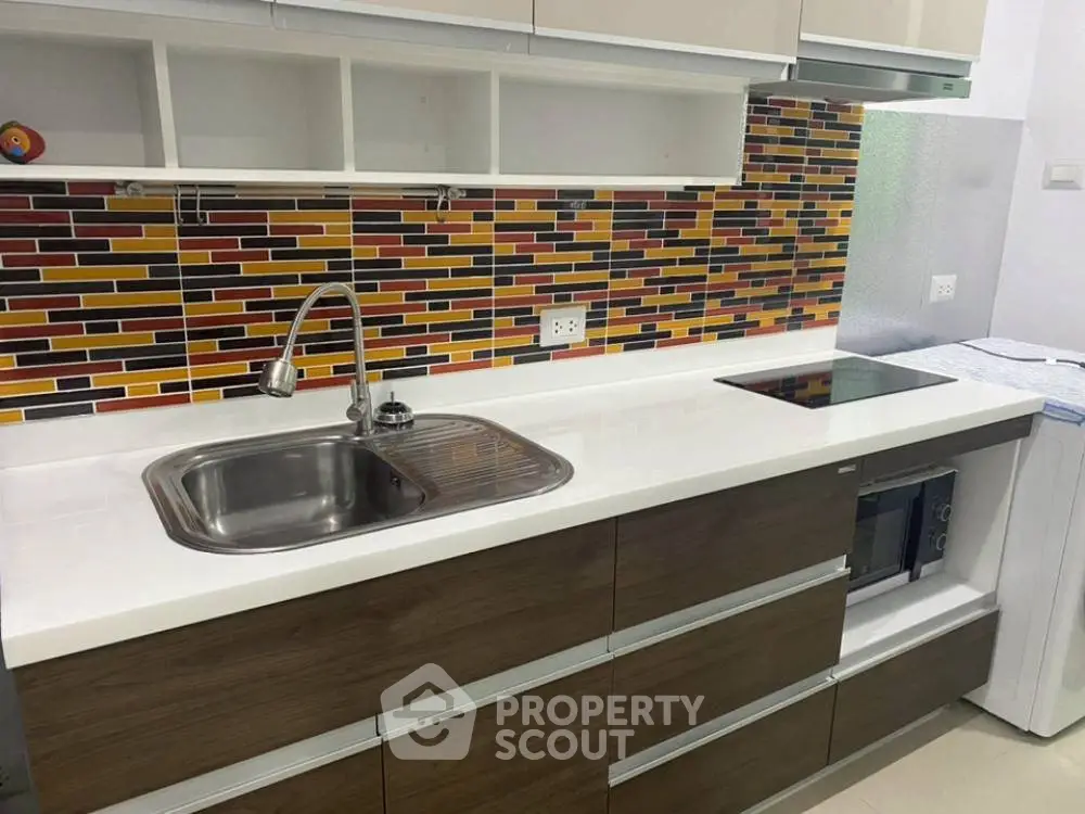 Modern kitchen with colorful backsplash and sleek appliances