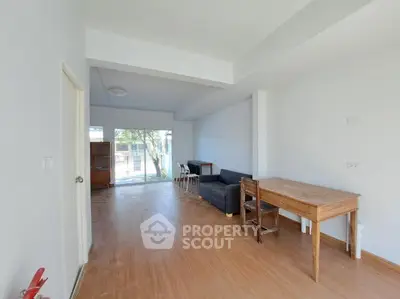 Spacious living room with wooden flooring and natural light