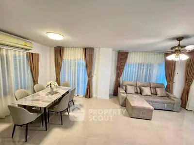 Spacious living room with elegant dining area and cozy sofa, perfect for modern living.