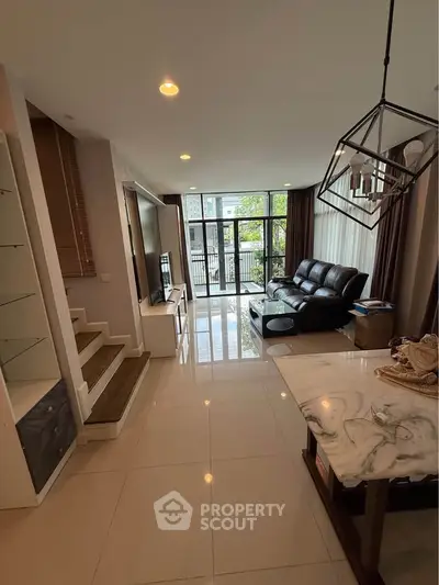 Spacious modern living room with large windows and elegant decor in a stylish home.