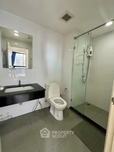 Modern bathroom with glass shower and sleek fixtures in a contemporary apartment.
