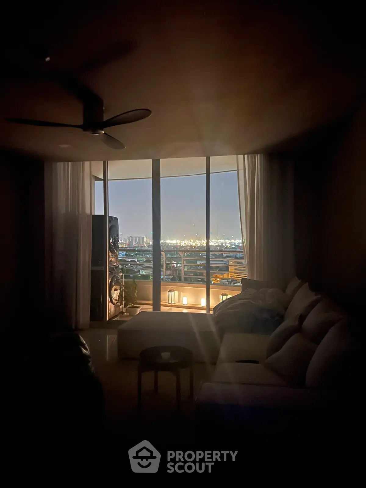 Cozy living room with stunning city view through large windows, perfect for relaxation and entertainment.