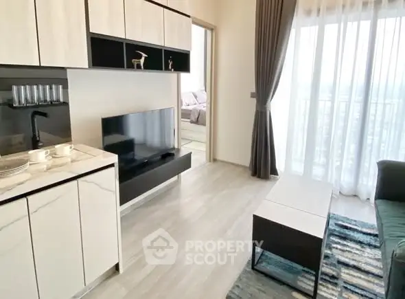 Modern living room with sleek furniture and natural light, adjacent to a cozy bedroom.
