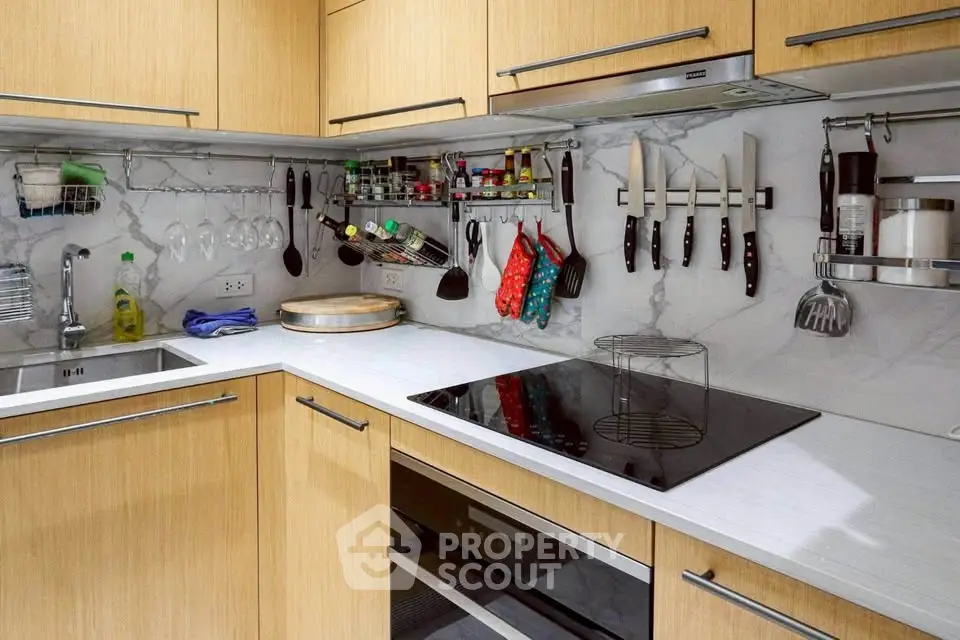 Modern kitchen with sleek cabinetry and built-in appliances, featuring a stylish open layout and elegant marble backsplash.