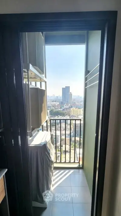 Compact balcony with city view, ideal for urban living, featuring laundry space and ample sunlight.