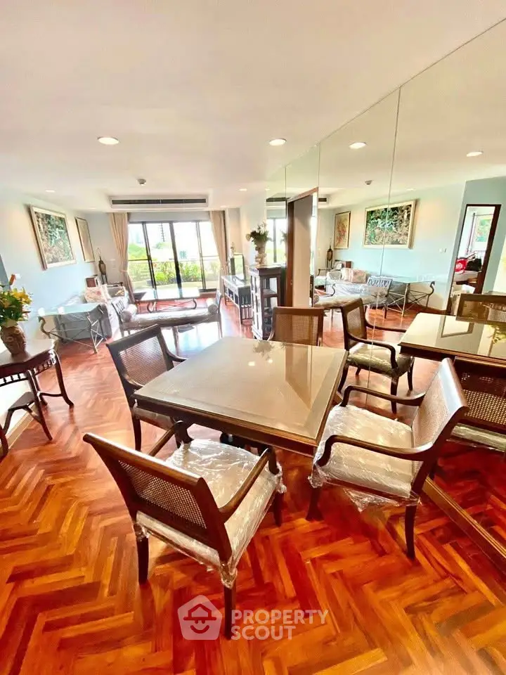 Elegant dining area with parquet flooring and stylish furniture in a spacious living room.
