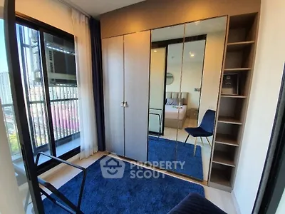 Modern bedroom with mirrored wardrobe and balcony view in urban apartment