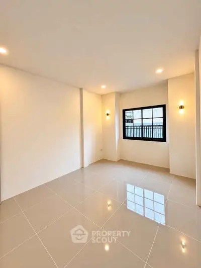 Spacious empty room with large window and glossy tiled floor, perfect for customization.