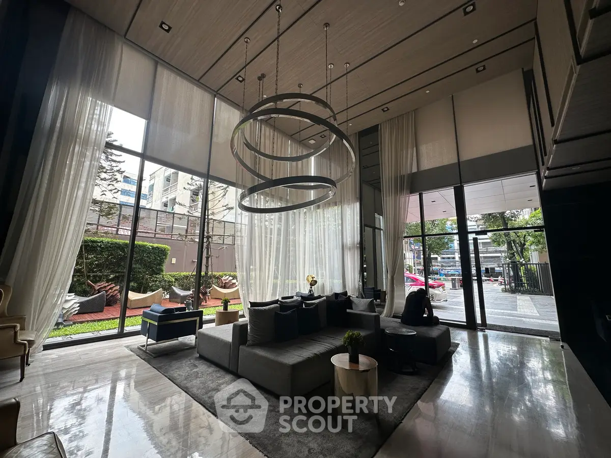 Luxurious modern living room with high ceilings and large windows overlooking a garden.