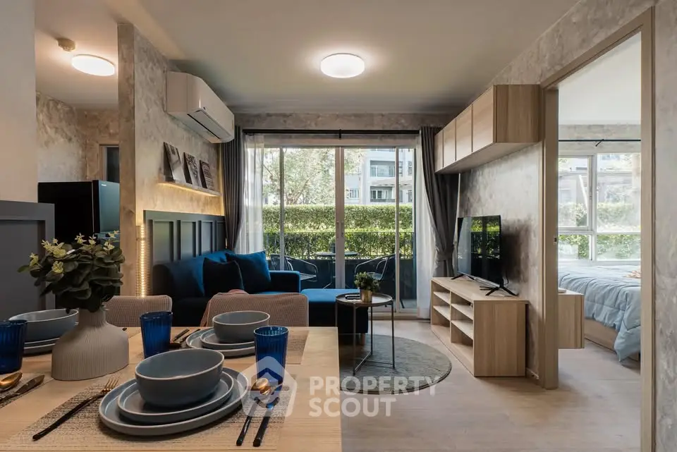 Modern open-plan living room with dining area and large windows overlooking greenery.