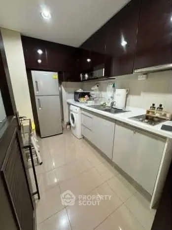 Modern kitchen with sleek cabinetry and appliances in a compact layout.