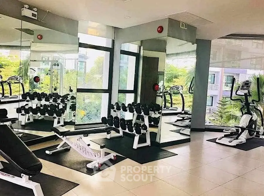 Modern gym with state-of-the-art equipment and mirrored walls in a residential building.