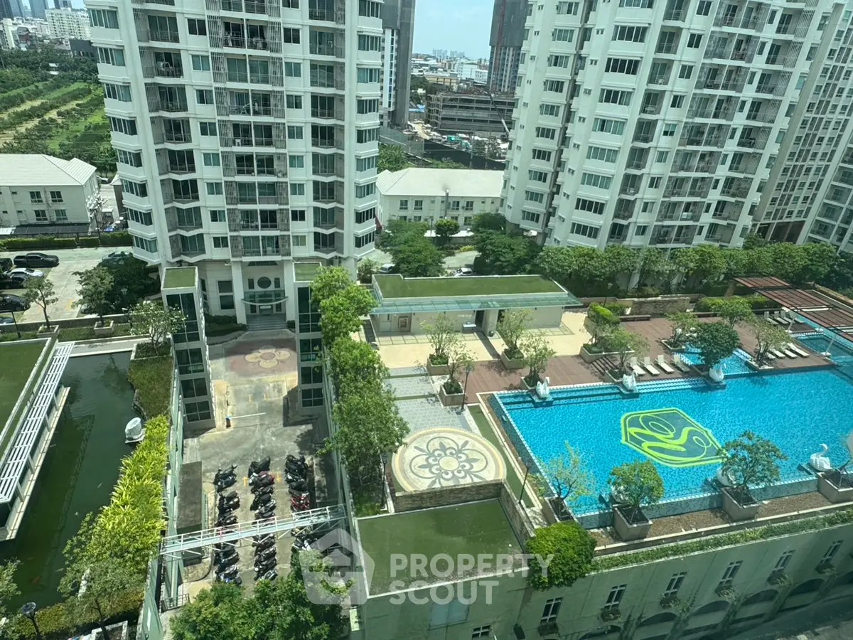 Stunning aerial view of luxury apartment complex with pool and lush landscaping.