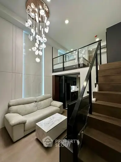 Luxurious modern living room with loft, elegant chandelier, and stylish staircase in a contemporary apartment.