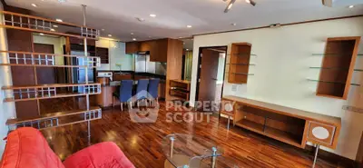 Spacious open-plan living room with modern kitchen and stylish wooden flooring.