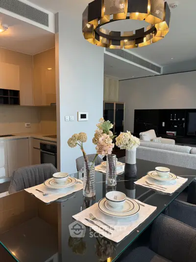 Luxurious dining area with elegant table setting and modern chandelier in open-plan living space.
