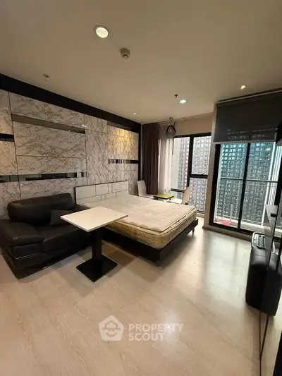 Modern studio apartment with stylish decor and city view balcony.