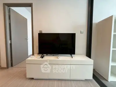 Modern living room with sleek TV stand and flat-screen TV, perfect for entertainment.