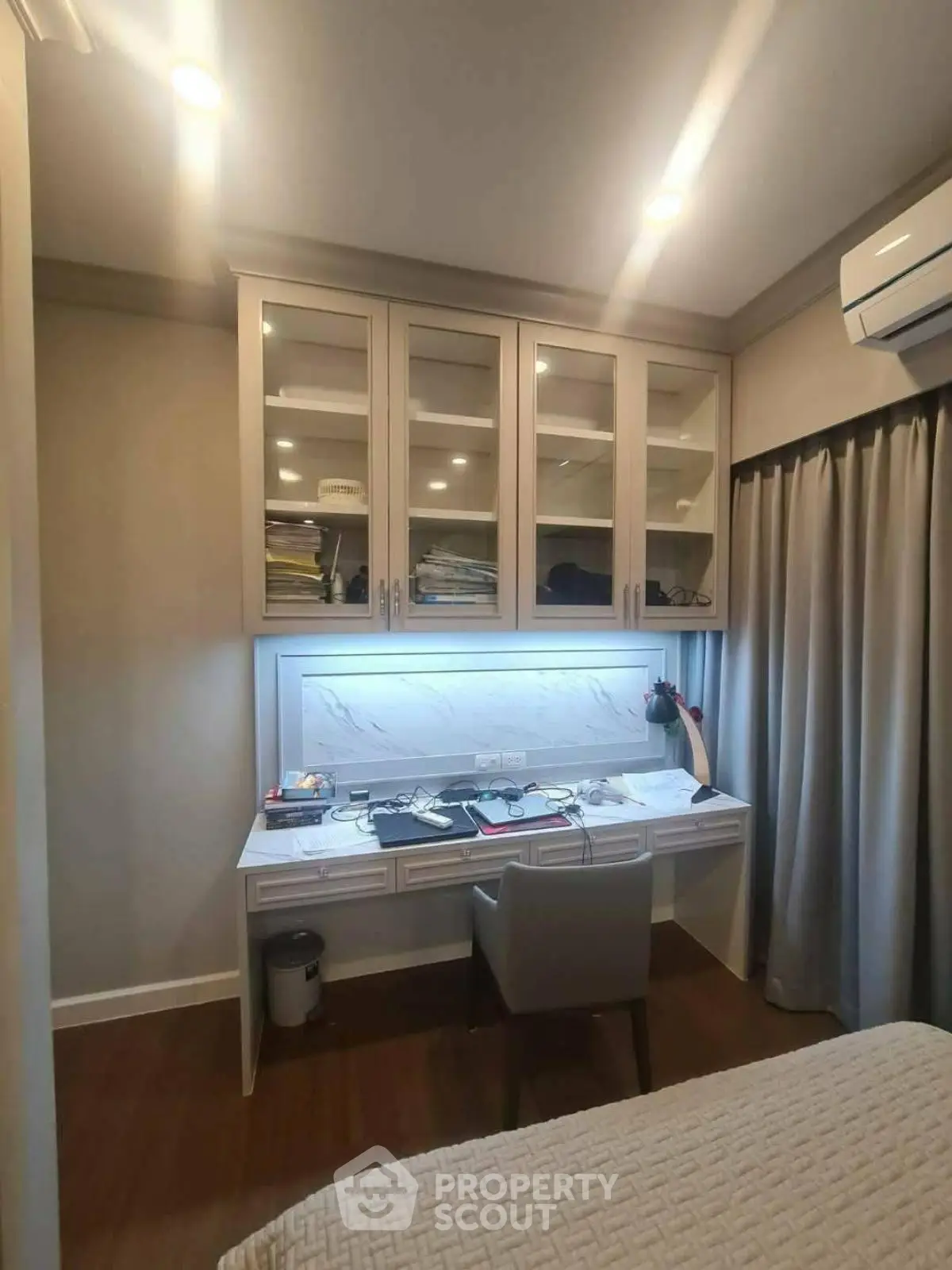 Modern study room with built-in desk and cabinets, featuring ambient lighting and sleek design.