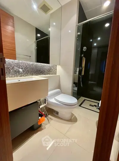 Modern bathroom with sleek design, featuring a glass shower and stylish vanity.