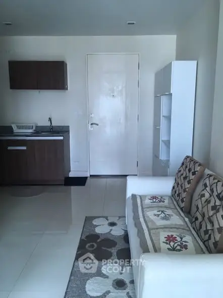 Modern living room with sleek furniture and compact kitchen area