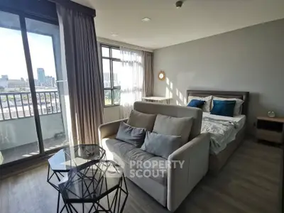 Modern studio apartment with large windows and city view, featuring a cozy living area and stylish bedroom.
