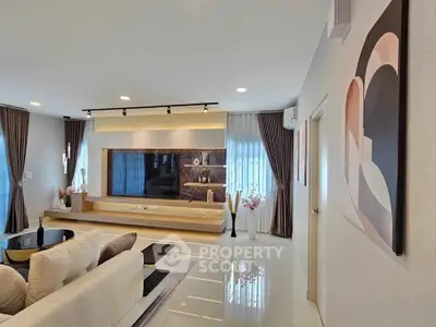 Modern living room with elegant decor and large windows, featuring a stylish entertainment center and cozy seating.