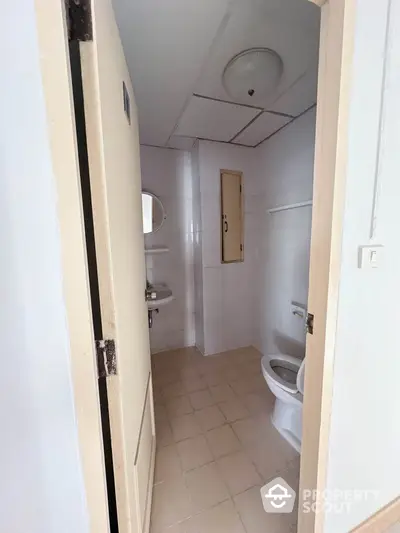 Compact bathroom with tiled floor and basic fixtures