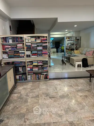 Spacious living room with bookshelves and cozy seating area, perfect for relaxation and reading.