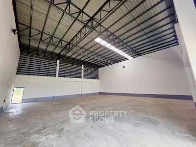 Spacious industrial warehouse with high ceilings and ample natural light, perfect for storage or manufacturing needs.