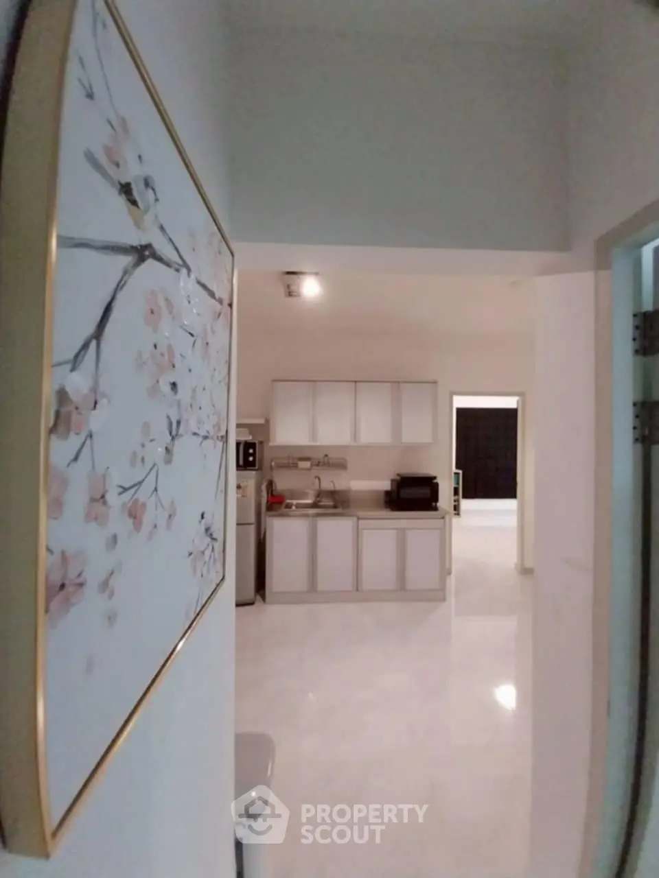 Modern kitchen with sleek cabinetry and elegant wall art in a spacious open layout.