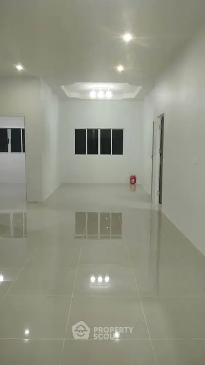 Spacious modern living room with glossy tiled floors and recessed lighting.