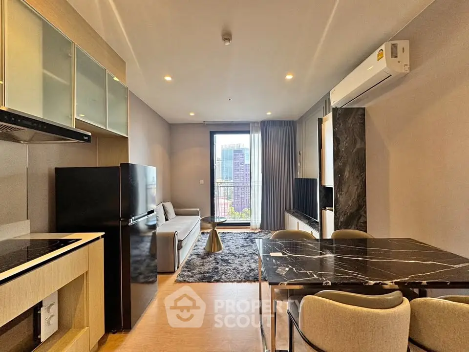 Modern living room with city view, sleek furniture, and open kitchen layout.