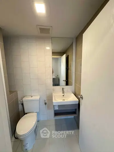Modern bathroom with sleek fixtures and neutral tiles, perfect for a contemporary home.