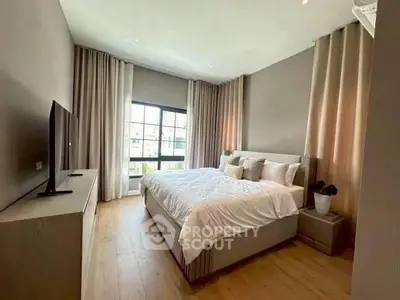 Spacious modern bedroom with large window and elegant decor