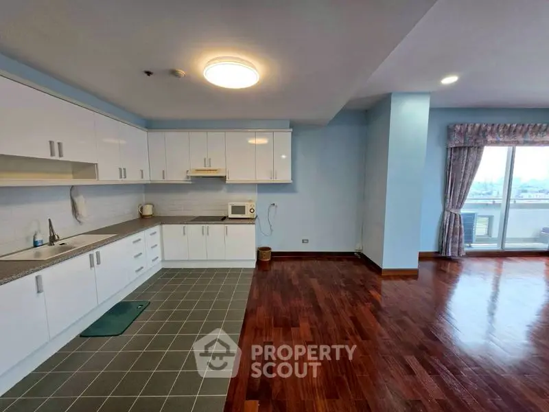 Spacious open-layout kitchen with hardwood floors and ample natural light.