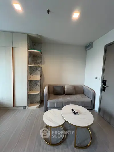 Modern living room with stylish sofa and marble coffee tables in a cozy apartment setting.