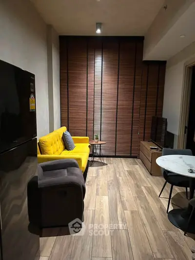 Modern living room with yellow sofa, sleek wooden flooring, and stylish decor