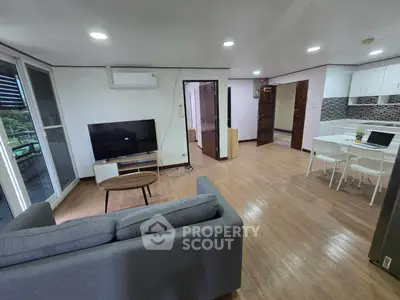 Spacious open-plan living room with modern kitchen and balcony view